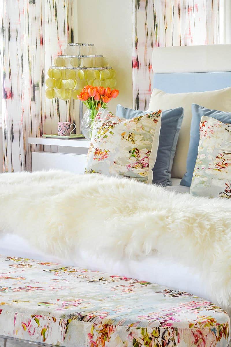 floral patterned bedroom with sheepskin throw